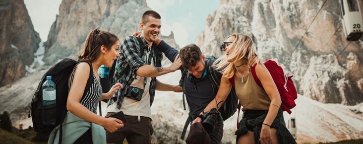Group of friends laughing together on a hike, representing connection, healing, and overcoming loneliness and social anxiety.